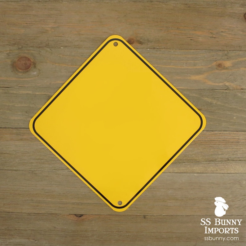May include: A blank, yellow, diamond-shaped metal sign with a black border and two holes for mounting. The sign is set against a wooden background. The logo for SS Bunny Imports is in the lower right corner.