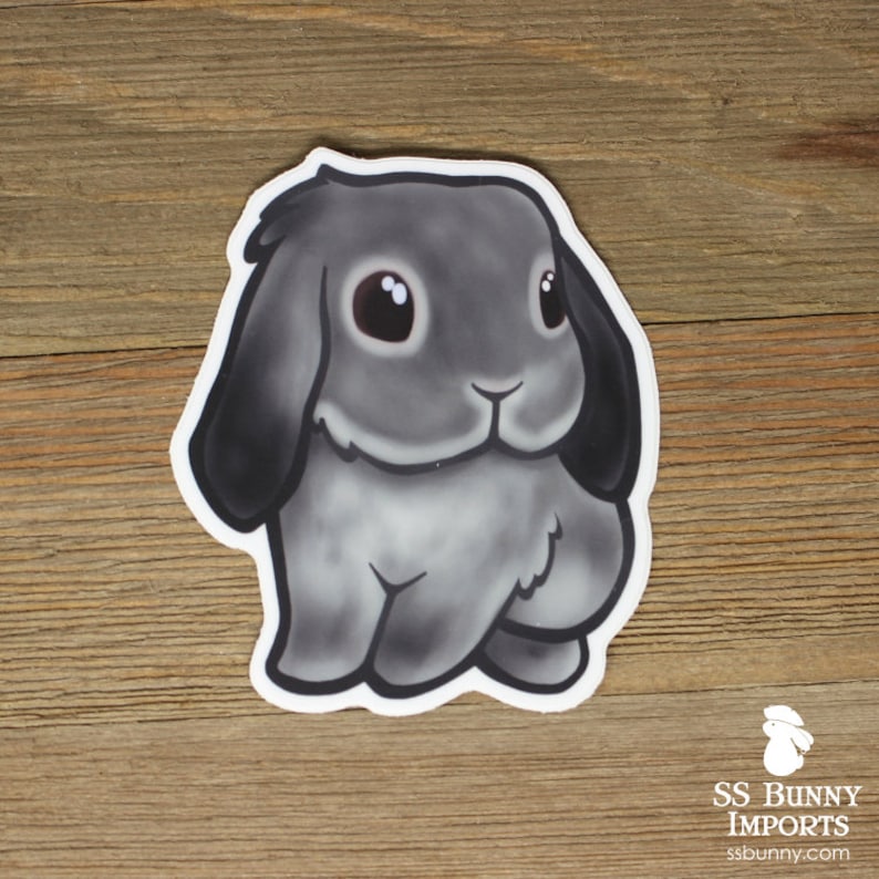 May include: A gray and white cartoon bunny rabbit sticker with big eyes and a fluffy tail. The bunny is sitting on its hind legs with its front paws tucked in.