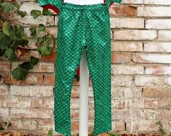 May include: Green and red mermaid costume with a cape and leggings. The leggings have a green scale pattern.