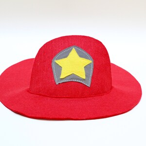 May include: Red felt firefighter hat with a yellow star on a gray patch.