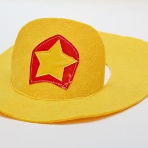 May include: A yellow felt cowboy hat with a red and yellow star patch.