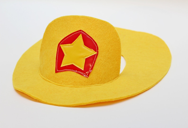 May include: A yellow felt cowboy hat with a red and yellow star patch.
