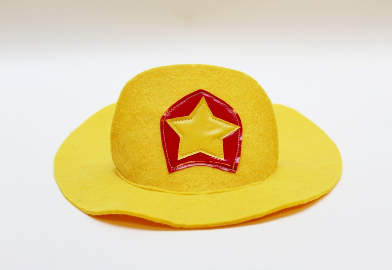 May include: A yellow felt cowboy hat with a red and yellow star patch.