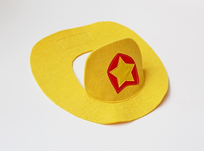 May include: A yellow felt cowboy hat with a red and yellow star patch.