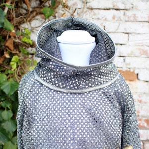 Op de afbeelding: Een zilveren sequined hoodie met een hoge hals. De hoodie is gemaakt van een zachte, rekbare stof en heeft een ontspannen pasvorm.