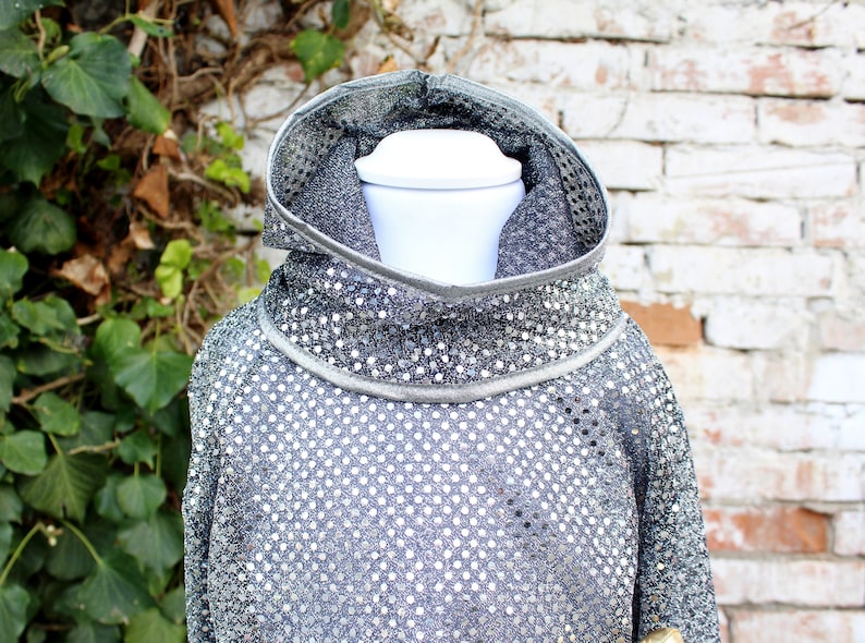Op de afbeelding: Een zilveren sequined hoodie met een hoge hals. De hoodie is gemaakt van een zachte, rekbare stof en heeft een ontspannen pasvorm.