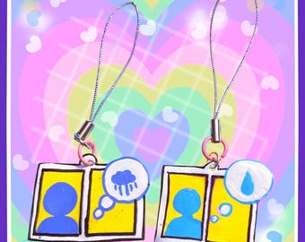 May include: Two handmade charm keychains with a yellow and white frame design. Each keychain features a blue silhouette and a thought bubble with a weather icon. One has a rain cloud, the other a water drop. The charms hang from a silver chain.
