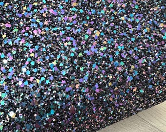 May include: A sheet of iridescent black glitter with a variety of sizes and shapes of glitter. The glitter has a blue, purple, and green iridescent sheen.