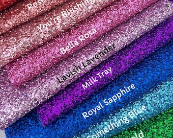 May include: A close-up of ten different glitter sheets, each with a unique color and name. The colors range from red to gold to pink to purple to blue to green to silver. The names are "In Love", "Rose Gold", "You're Blushing", "Bella Rosa", "Lavish Lavender", "Milk Tray", "Royal Sapphire", "Something Blue", "Emerald", and "Hollywood".
