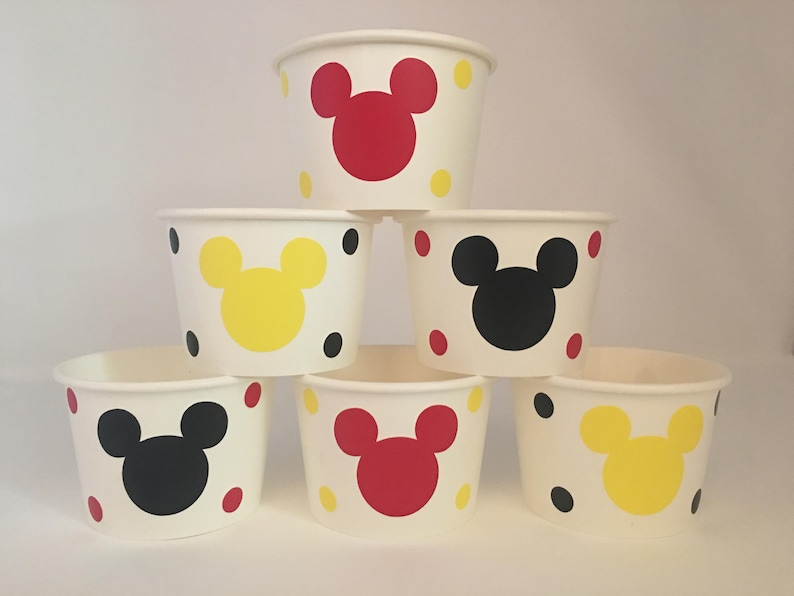 K&ouml;nnte beinhalten: Sechs wei&szlig;e Pappbecher mit roten, gelben und schwarzen Mickey-Maus-Gesichtern und Punkten.