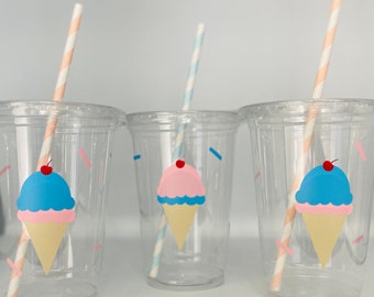 May include: Three clear plastic cups with ice cream cone designs. Each cup has a different colored ice cream cone: blue, pink, and blue. Each cup has a striped paper straw.