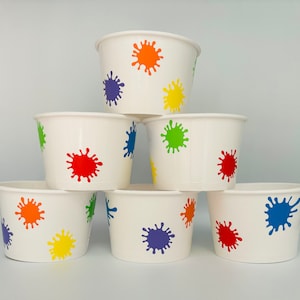 K&ouml;nnte beinhalten: Sechs wei&szlig;e Pappbecher mit bunten Farbklecksmustern. Die Becher sind pyramidenf&ouml;rmig gestapelt. Die Farben der Farbklecksmuster sind rot, orange, gelb, gr&uuml;n, blau und lila.