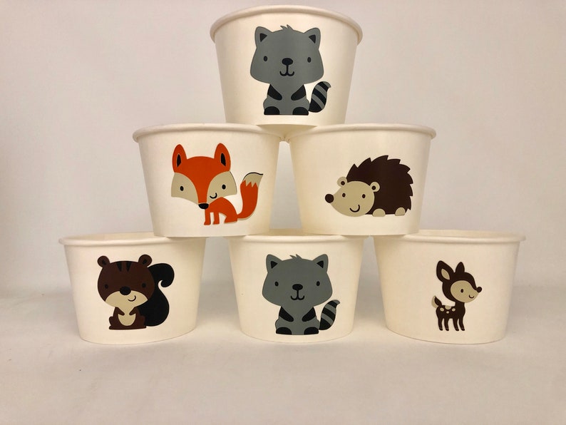 Puede incluir: Seis vasos de papel blancos con diferentes dise&ntilde;os de animales del bosque. Los vasos presentan un zorro, un mapache, un erizo, una ardilla y un ciervo.