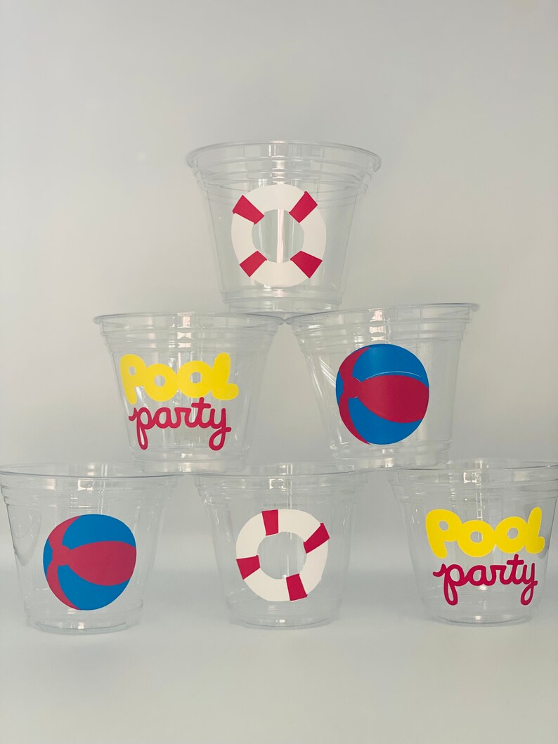 May include: Six clear plastic cups with different pool party designs. The designs include a yellow "Pool Party" text, a red and white life preserver, and a red and blue beach ball.
