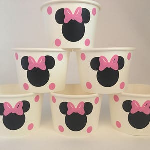 May include: Six white paper cups with pink polka dots and a black and pink Minnie Mouse design.