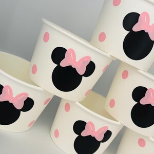 Puede incluir: Conjunto de vasos de papel blancos con lunares rosas y un dise&ntilde;o de Minnie Mouse negro y rosa.