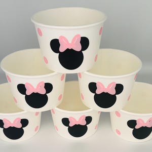 Puede incluir: Conjunto de seis vasos de papel blancos con lunares rosas y un dise&ntilde;o de Minnie Mouse negro y rosa.