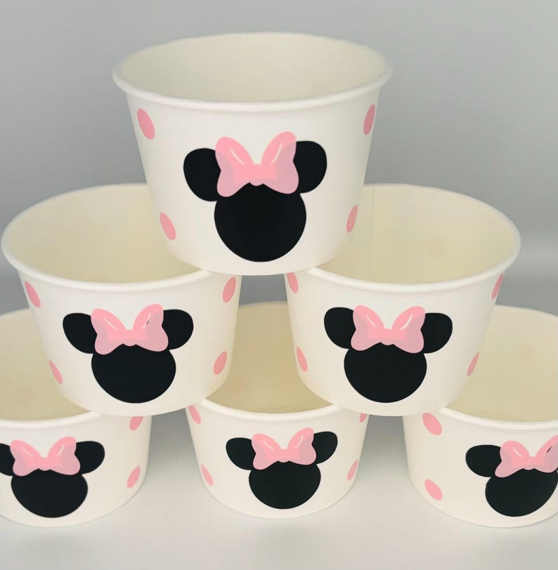 Puede incluir: Conjunto de seis vasos de papel blancos con lunares rosas y un dise&ntilde;o de Minnie Mouse negro y rosa.
