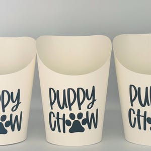 May include: Three white paper cups with a black paw print and the text "Puppy Chow" printed on them.