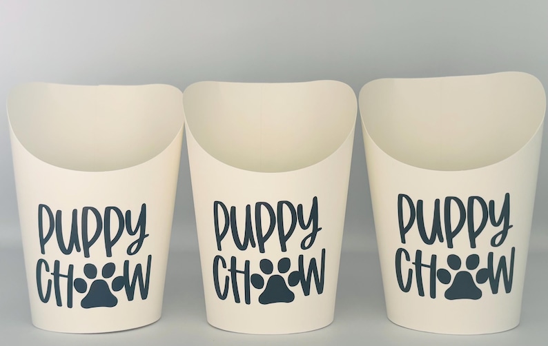 May include: Three white paper cups with a black paw print and the text "Puppy Chow" printed on them.