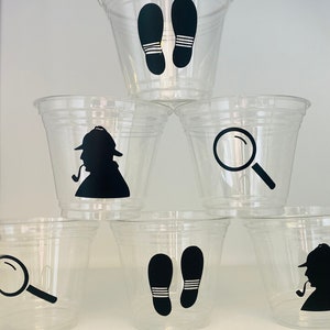 以下が含まれることがあります： 黒いシルエットのデザインが施された透明なプラスチックカップ6個。デザインには、虫眼鏡、足跡、パイプを持った探偵が含まれています。