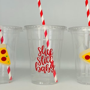 May include: Three clear plastic cups with red and white striped straws. Each cup has a pizza slice sticker with red pepperoni and green peppers. The middle cup has the text "Slice Slice Baby" in red.
