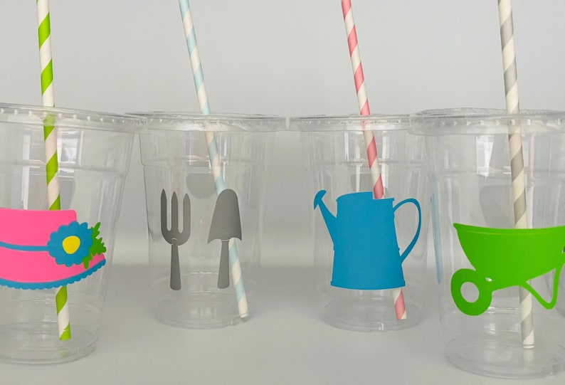 Pu&ograve; includere: Quattro bicchieri di plastica trasparente con cannucce di carta colorate e adesivi a tema giardinaggio. Gli adesivi includono un cappello, una forchetta e una vanga, un annaffiatoio e un carretto.
