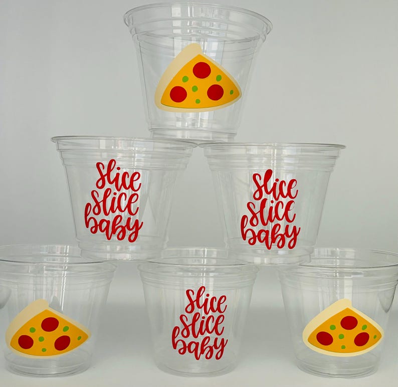 Op de afbeelding: Zes doorzichtige plastic bekers met rode en gele pizza-plakjes ontwerpen en de tekst "Slice Slice Baby" op de bekers.
