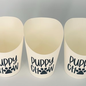 May include: Three white paper cones with black text that reads "Puppy Chow" and a black paw print.