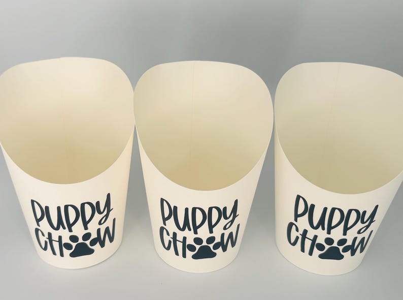 May include: Three white paper cones with black text that reads "Puppy Chow" and a black paw print.