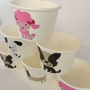 Pu&ograve; includere: Set di sei bicchieri di carta bianchi con diverse illustrazioni di cani. I bicchieri presentano un barboncino rosa, un cane bianco e nero, un cane marrone e un cane marrone.