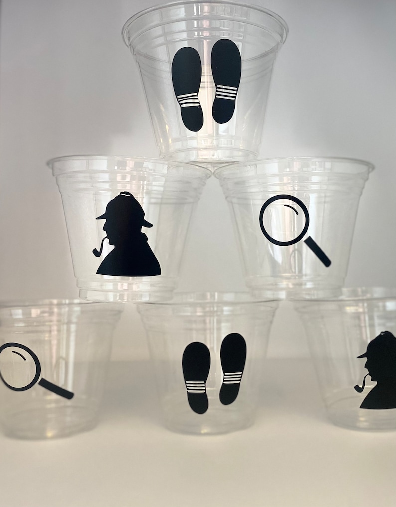 以下が含まれることがあります： 黒いシルエットのデザインが施された透明なプラスチックカップ6個。デザインには、虫眼鏡、足跡、パイプを持った探偵が含まれています。