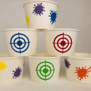 Peut inclure: Six gobelets en papier blanc avec des motifs diff&eacute;rents. Les gobelets ont un motif de peinture &eacute;clabouss&eacute;e bleu, rouge, vert, jaune et violet. Trois des gobelets ont un motif de cible de tir &agrave; l'arc bleu, rouge et vert.