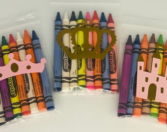 May include: Three clear plastic bags each containing a set of 10 Crayola crayons. The bags are decorated with paper cutouts of a crown, a castle, and a crown.