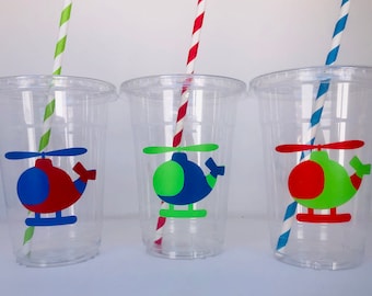 May include: Three clear plastic cups with straws and helicopter designs. The helicopters are red, green, and blue with different color accents.