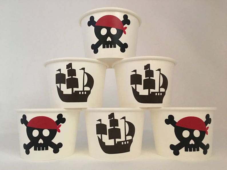 Peut inclure: Six gobelets en papier blanc avec des motifs pirates noirs et rouges. Les motifs comprennent un cr&acirc;ne et des os crois&eacute;s, un navire pirate et un chapeau de pirate.