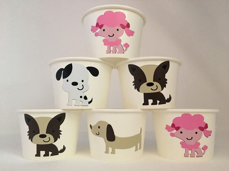 Pu&ograve; includere: Sei bicchieri di carta bianchi con diversi disegni di animali. I bicchieri presentano un barboncino rosa, un cane bianco e nero, un cane marrone, un bassotto, un cane marrone e bianco e un barboncino rosa.