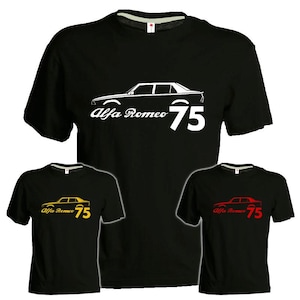 Può includere: T-shirt nere con grafica di auto e la scritta "Alfa Romeo 75". La grafica e il testo sono bianchi, gialli e rossi. Le magliette sono a maniche corte e hanno un girocollo.