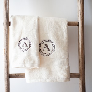 Soft cotton terry towels, personalized with an embroidered initial and double decorative garland