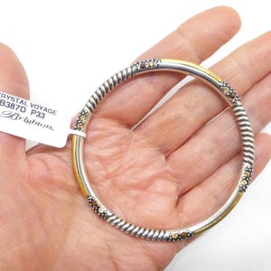 Puede incluir: Una pulsera de brazalete plateada con un dise&ntilde;o de cuerda trenzada y detalles dorados. La pulsera presenta peque&ntilde;os adornos redondos de color &aacute;mbar. La etiqueta dice "Crystal Voyage JB387D P33 Brighton."