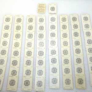 May include: A collection of vintage Panic Brewing Co. cards, arranged on a white surface. The cards are rectangular with a cream background and black text and graphics. The cards are arranged in rows, with a few additional cards and a small paper sheet.