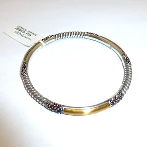 Puede incluir: Pulsera plateada con dise&ntilde;o de cuerda trenzada y detalles dorados. La pulsera presenta peque&ntilde;os cristales de color marr&oacute;n y una etiqueta que dice "Crystal Voyage JB387D P33 Brighton."