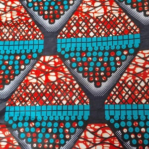 May include: A colourful fabric with a repeating geometric pattern. The design features red, white, and black shapes with a turquoise border and a dark background. The pattern includes dots and lines, creating a bold textile.