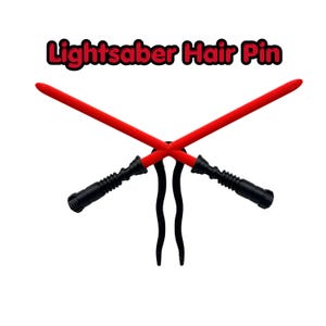 May include: A hair pin featuring two crossed red lightsabers with black handles. The text "Lightsaber Hair Pin" is above the lightsabers in red and black.