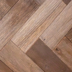 May include: Close-up of a herringbone pattern made of reclaimed wood planks. The planks vary in color from light tan to dark brown, with visible wood grain and knots. The pattern creates a textured, rustic appearance.
