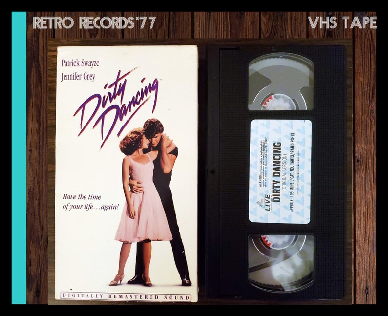May include: VHS tape case for the movie Dirty Dancing, featuring Patrick Swayze and Jennifer Grey on the cover. The text on the case reads "Dirty Dancing", "Have the time of your life...again!" and "Digitally Remastered Sound".