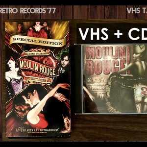 May include: A VHS tape and CD set of the movie Moulin Rouge! featuring Nicole Kidman and Ewan McGregor. The VHS tape cover features a red background with the title "Moulin Rouge!" in white text. The CD cover features a black and white image of a woman in a red dress and a red feather boa. The text "Moulin Rouge!" is in red and white text on the CD cover.