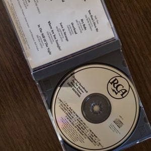 May include: A silver compact disc with a gold RCA logo and the text "Original Soundtrack for the Vestron Motion Picture Dirty Dancing" printed on the front. The disc includes a list of songs from the movie, including "(I've Had) The Time of My Life", "She's Like the Wind", "Hungry Eyes", and "Love Is Strange".
