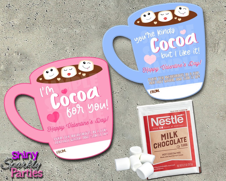 May include: Valentine's Day themed gift set featuring two mug-shaped cards with cocoa and marshmallow designs, and a Nestle Milk Chocolate Hot Cocoa Mix packet. The pink card says "I'm Cocoa for you!" and the blue card says "You're kinda Cocoa but I like it!"