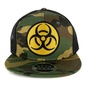 May include: A black and green camouflage trucker hat with a yellow biohazard symbol on the front. The hat has a black mesh back and a snap closure.